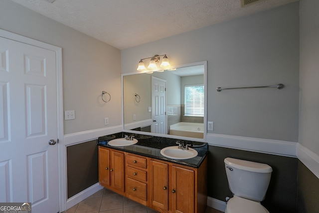 bathroom with tile patterned flooring, a bathtub, toilet, and a textured ceiling