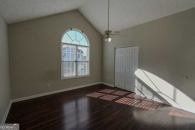 unfurnished room featuring a textured ceiling, ceiling fan, dark hardwood / wood-style flooring, and lofted ceiling