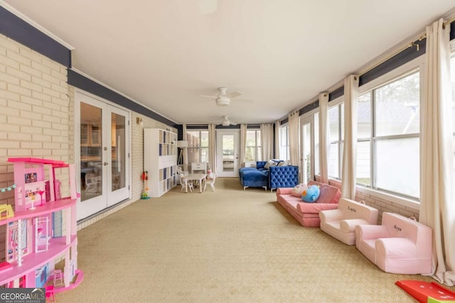 sunroom / solarium with french doors, plenty of natural light, and ceiling fan