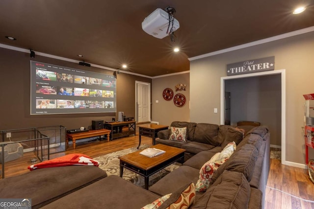 cinema room featuring wood-type flooring and ornamental molding