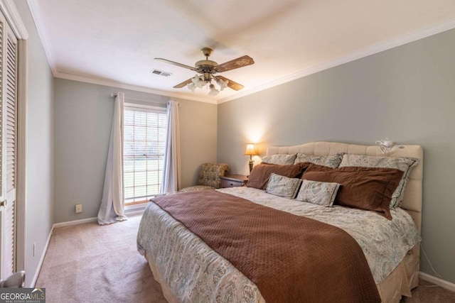 bedroom with light carpet, a closet, ceiling fan, and crown molding