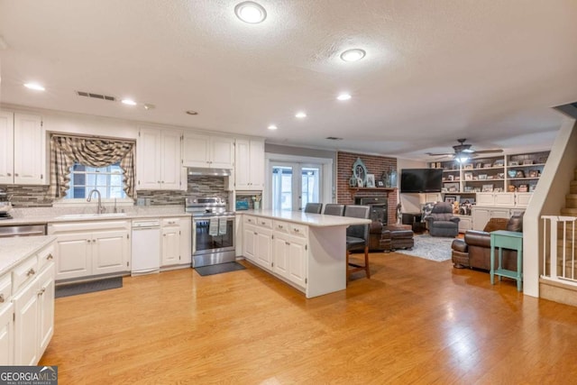 kitchen with white cabinets, a wealth of natural light, and appliances with stainless steel finishes