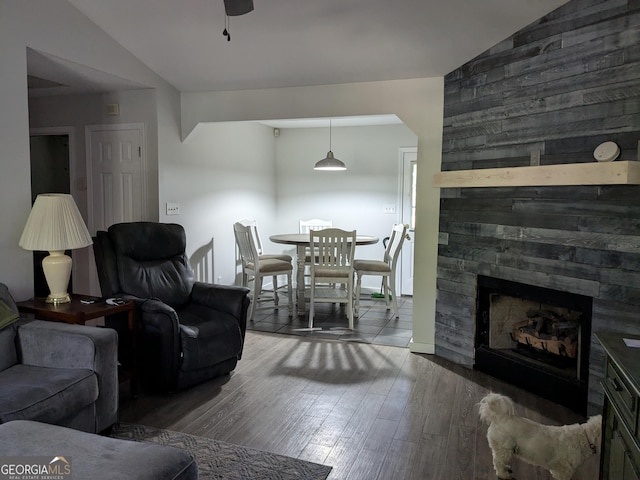 living room featuring lofted ceiling, a fireplace, ceiling fan, and dark hardwood / wood-style floors