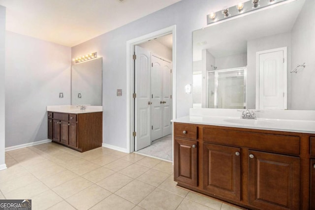 bathroom with tile patterned floors, vanity, and an enclosed shower