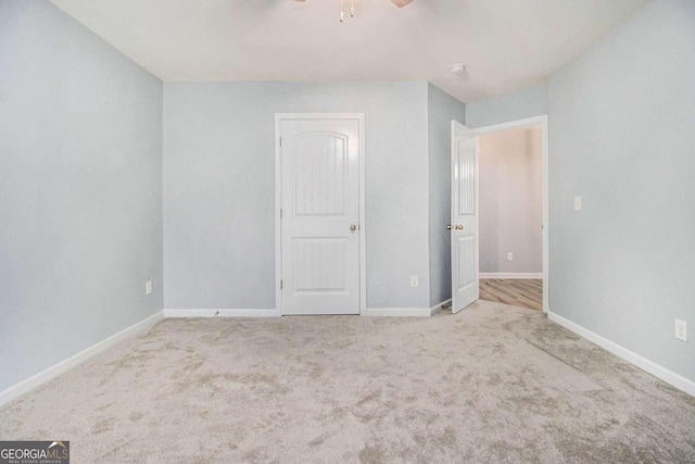 carpeted spare room featuring ceiling fan