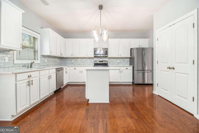 kitchen with white cabinets, pendant lighting, stainless steel appliances, and a kitchen island