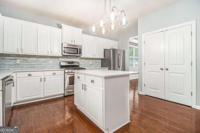 kitchen featuring a center island, hanging light fixtures, dark wood-type flooring, stainless steel appliances, and white cabinets