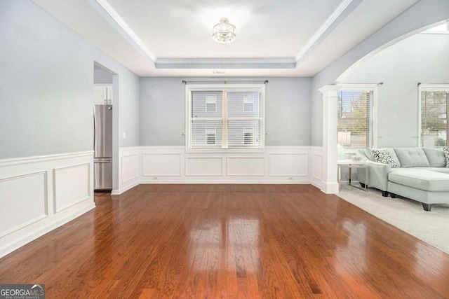 interior space with a raised ceiling and hardwood / wood-style floors