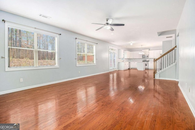 unfurnished living room featuring hardwood / wood-style flooring and ceiling fan