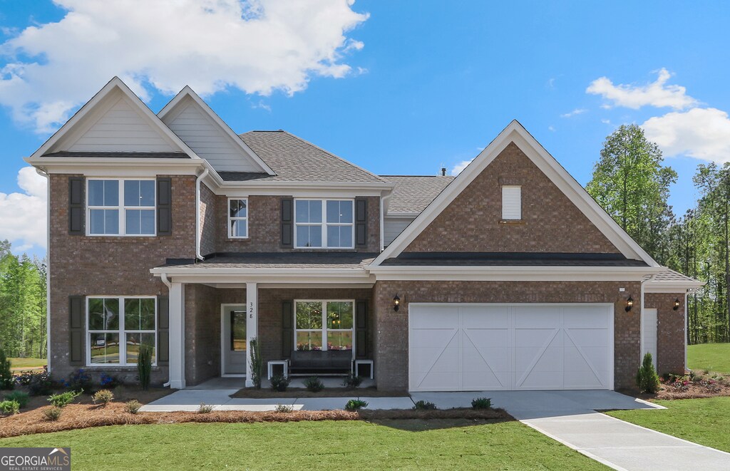 craftsman inspired home featuring a porch, a garage, and a front lawn