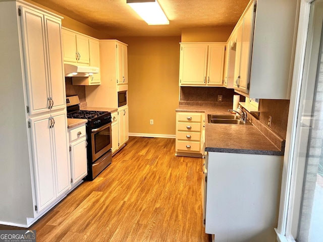 kitchen with white cabinetry, dark hardwood / wood-style floors, stainless steel gas range, and built in microwave