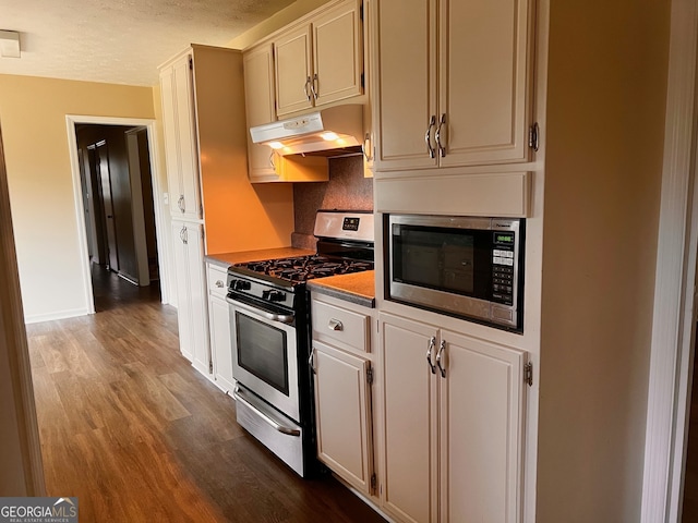 kitchen featuring decorative backsplash, hardwood / wood-style flooring, a textured ceiling, and appliances with stainless steel finishes