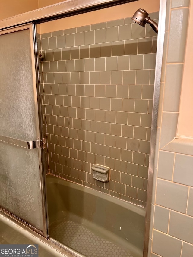 bathroom with combined bath / shower with glass door