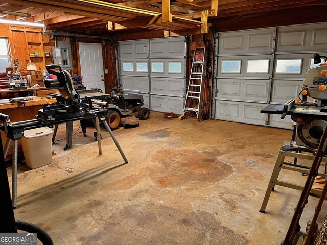 garage featuring wood walls and a workshop area