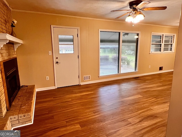 unfurnished living room featuring crown molding, a textured ceiling, a fireplace, wood-type flooring, and ceiling fan