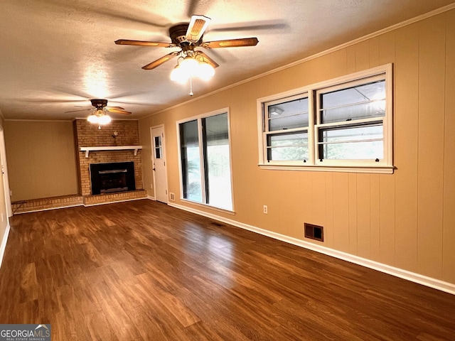 unfurnished living room featuring ornamental molding, dark hardwood / wood-style floors, and a textured ceiling