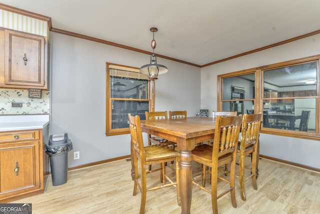 dining room with light wood-type flooring and ornamental molding