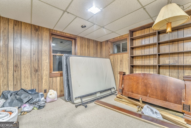 misc room with carpet floors, a paneled ceiling, and wood walls