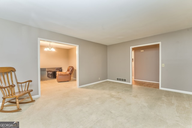 spare room with carpet and an inviting chandelier