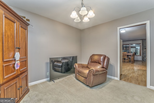 sitting room featuring light colored carpet and an inviting chandelier