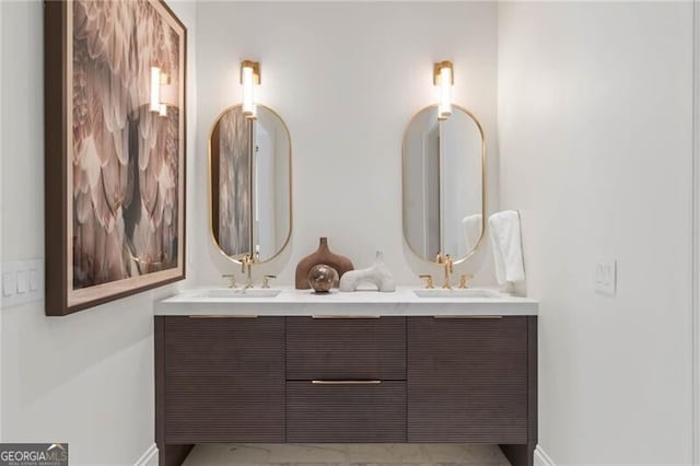 bathroom with a sink, baseboards, and double vanity