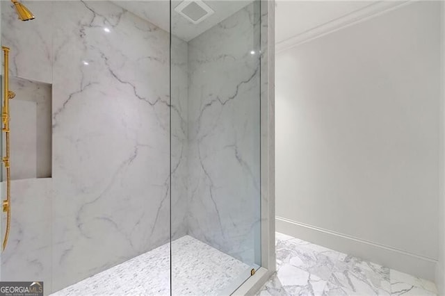 full bathroom featuring ornamental molding, a marble finish shower, baseboards, and marble finish floor