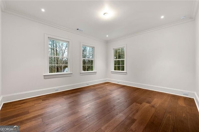 empty room with baseboards, dark wood-style floors, and ornamental molding