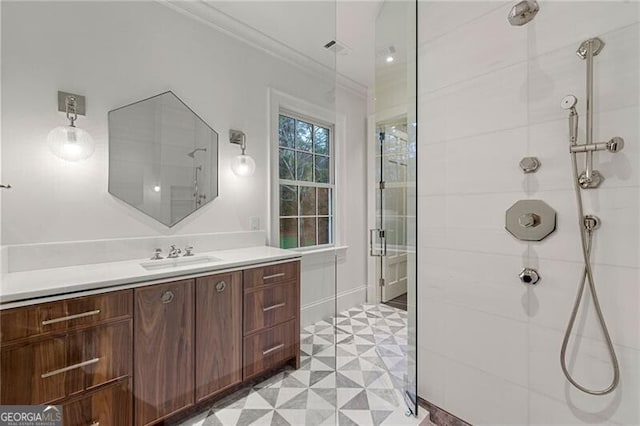 bathroom featuring vanity, ornamental molding, tiled shower, and tile patterned floors