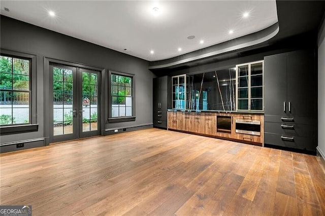 bar featuring french doors, wood finished floors, and a healthy amount of sunlight