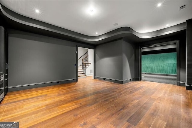 unfurnished room featuring stairway, light wood finished floors, visible vents, and recessed lighting