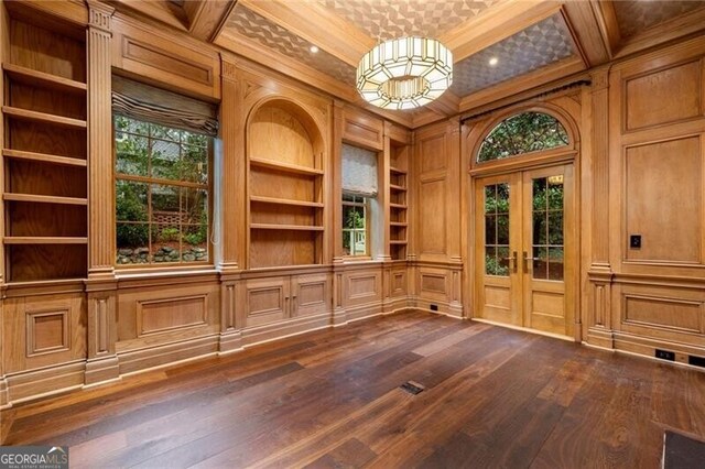 interior space featuring a wealth of natural light, dark wood finished floors, built in features, and coffered ceiling