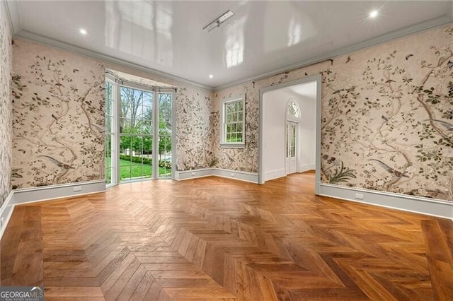 empty room with wallpapered walls, baseboards, and crown molding