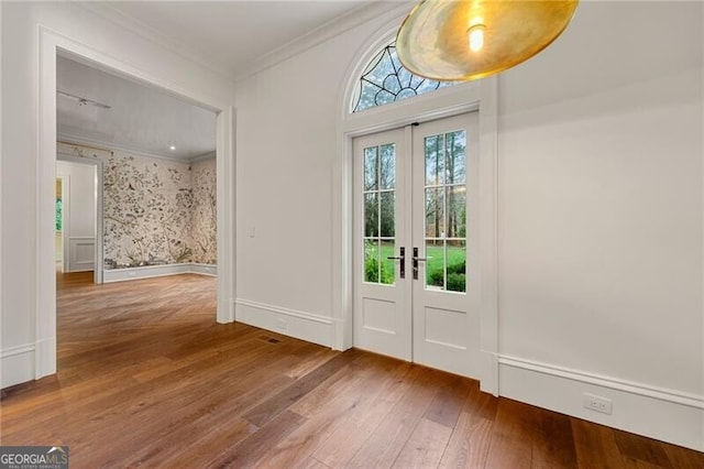 doorway featuring ornamental molding, baseboards, wallpapered walls, wood finished floors, and french doors