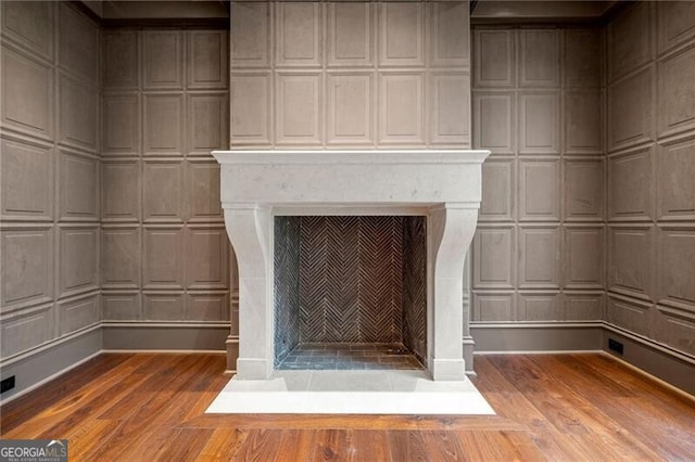 interior details with wood finished floors and a fireplace with flush hearth