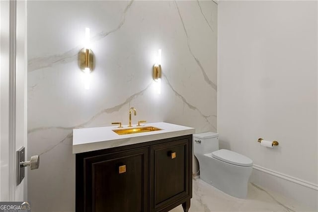 bathroom with vanity, toilet, and marble finish floor