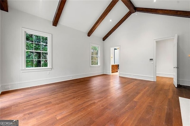 unfurnished living room featuring baseboards, high vaulted ceiling, beamed ceiling, and wood finished floors