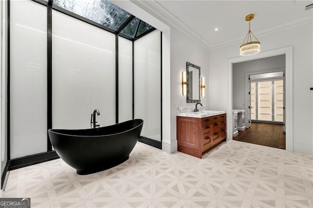 full bath with ornamental molding, visible vents, baseboards, a freestanding tub, and vanity