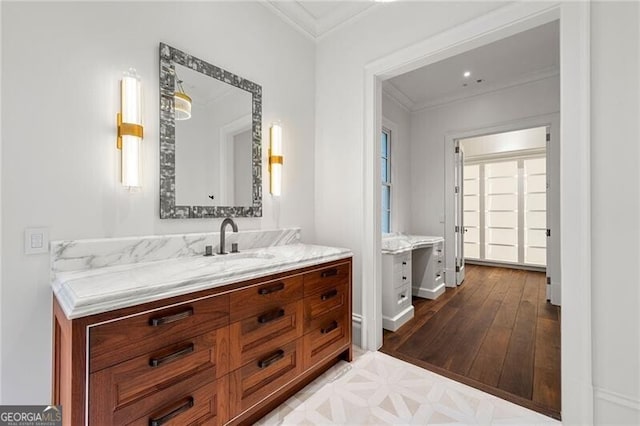 full bathroom with two vanities, baseboards, a sink, parquet flooring, and crown molding