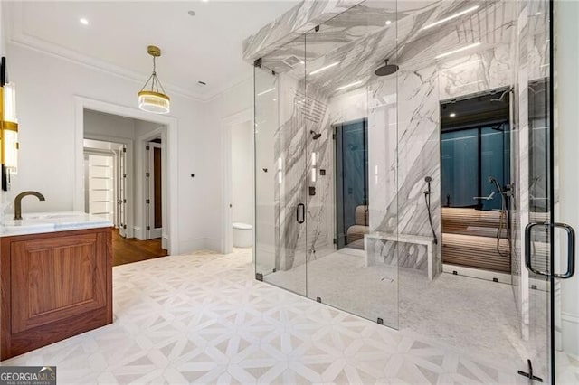 bathroom with ornamental molding, a marble finish shower, baseboards, toilet, and vanity