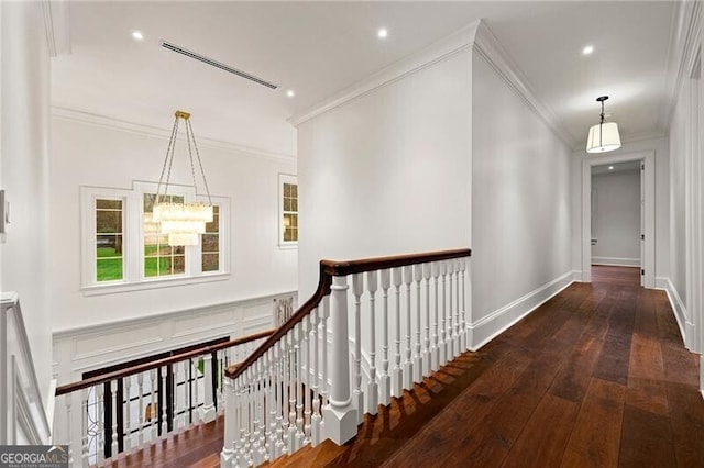 hallway with ornamental molding, dark wood-style flooring, and an upstairs landing