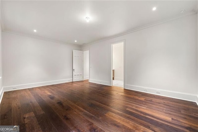 unfurnished room featuring dark wood finished floors, baseboards, and crown molding