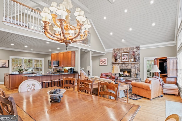 kitchen featuring a stone fireplace, a breakfast bar area, light wood-type flooring, a kitchen island, and stainless steel appliances