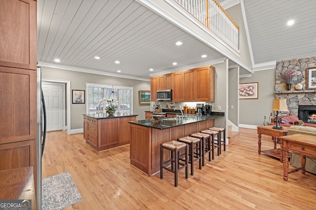 dining space featuring french doors, light wood-type flooring, crown molding, high vaulted ceiling, and a fireplace