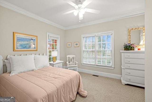 carpeted bedroom with multiple windows, ceiling fan, crown molding, and ensuite bathroom