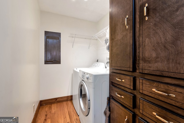 laundry area with cabinets, light wood-type flooring, electric panel, and washing machine and clothes dryer