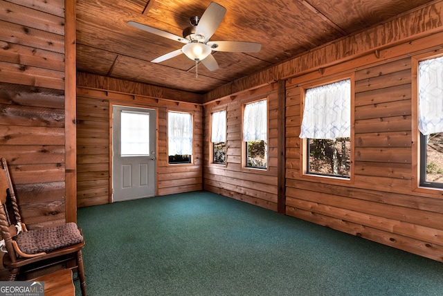 unfurnished sunroom featuring ceiling fan, a healthy amount of sunlight, and wooden ceiling