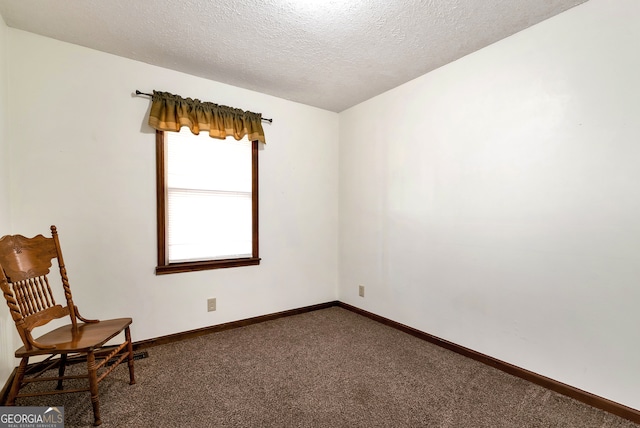 unfurnished room with dark colored carpet and a textured ceiling