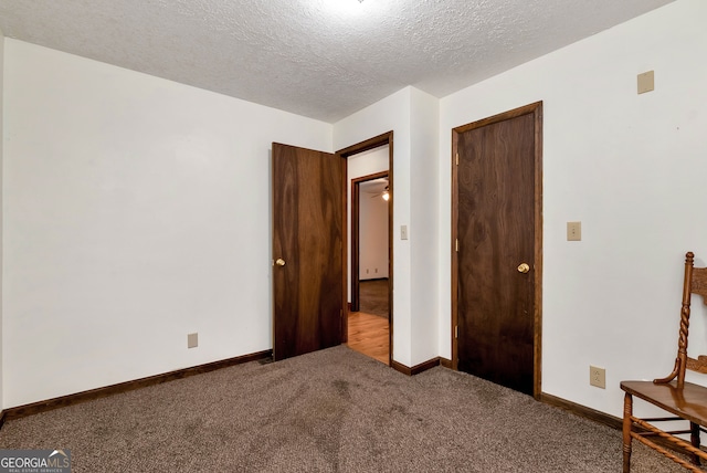 unfurnished bedroom featuring carpet, a textured ceiling, and a closet