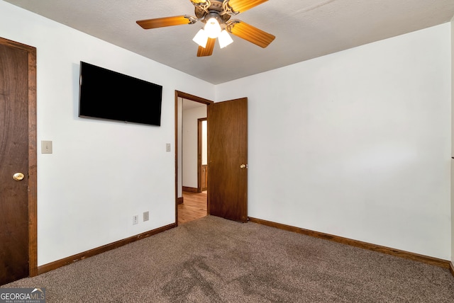 spare room featuring carpet, a textured ceiling, and ceiling fan