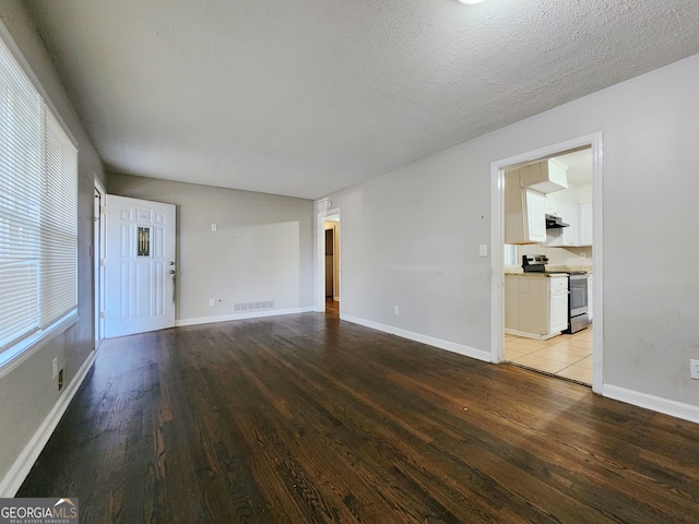 unfurnished living room featuring light wood-type flooring and a textured ceiling